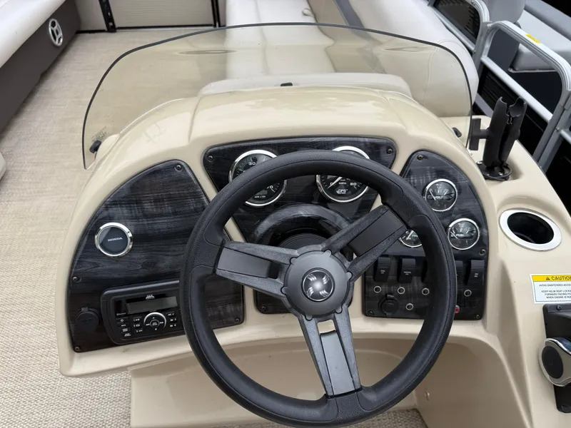Slide: The Image of Steering console of a 2017 Sweetwater 22 boat with gauges and controls. - 14