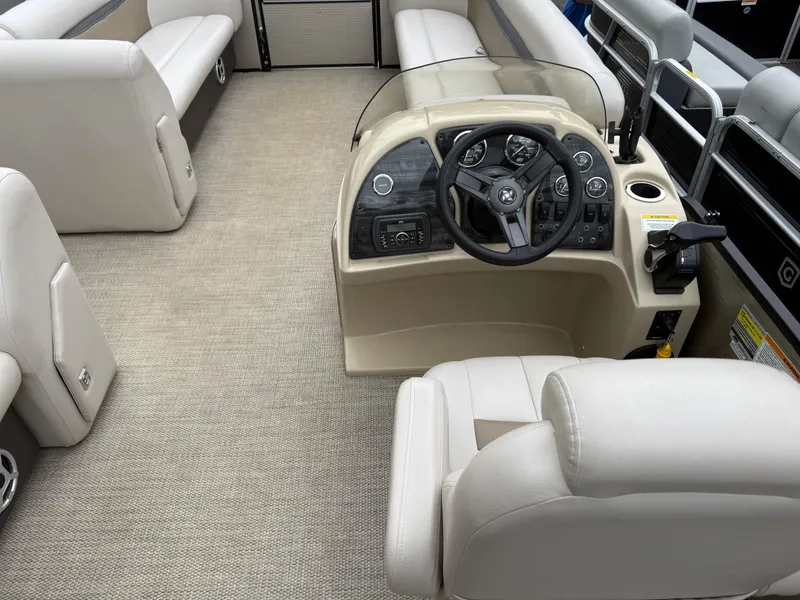 Slide: The Image of 2017 Sweetwater 22 boat interior with beige seating and steering console. - 17