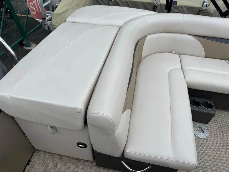 Slide: The Image of 2017 Sweetwater 22 boat interior with white cushioned seating and cup holders. - 18