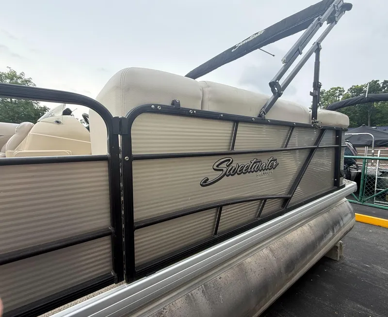 Slide: The Image of 2017 Sweetwater 22 pontoon boat with beige seating and black railing. - 2