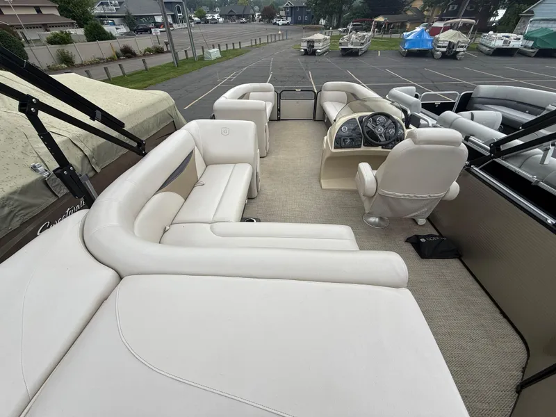 Slide: The Image of 2017 Sweetwater 22 pontoon boat interior with beige seating and steering console. - 20