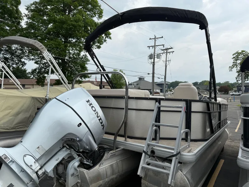 Slide: The Image of 2017 Sweetwater 22 pontoon boat with Honda outboard motor and canopy, parked outdoors. - 5
