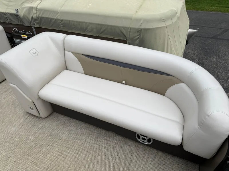 Slide: The Image of White and beige seating on a 2017 Sweetwater 22 boat, covered in a protective tarp. - 7