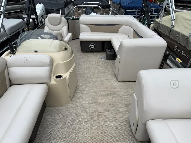 Slide: The Image of 2017 Sweetwater 22 pontoon boat interior with beige seating and steering console. - 9