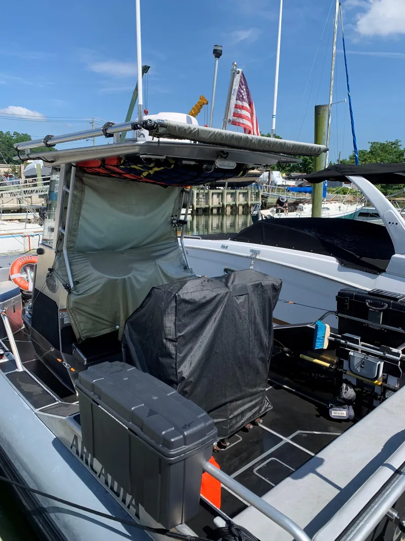Slide: The Image of 2023 Life Proof 21 Hard Top boat docked, featuring covered equipment and American flag. - 3