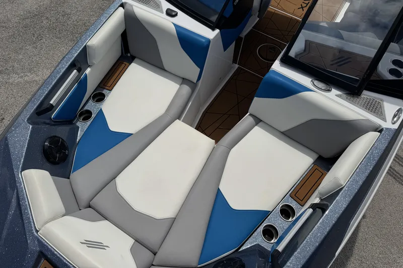 Slide: The Image of 2021 ATX Surf Boats 22 Type-S interior with blue and white seating, cup holders, and sleek design. - 8