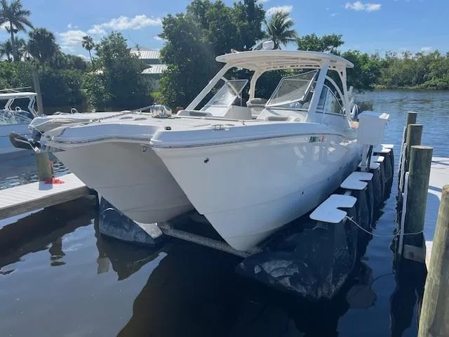 Slide: The Image of 2022 World Cat 296 DC boat docked by a scenic waterfront. - 3