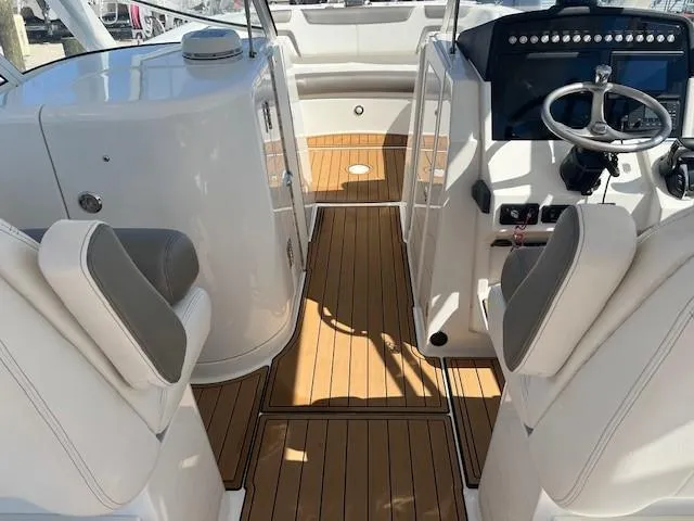 Slide: The Image of 2022 World Cat 296 DC boat interior with teak flooring and modern helm controls. - 6