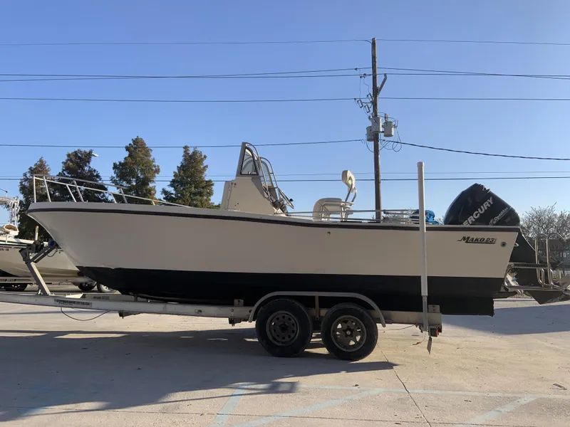 Slide: The Image of 1988 Mako 231 Center Console boat on trailer, side view, clear sky background. - 10