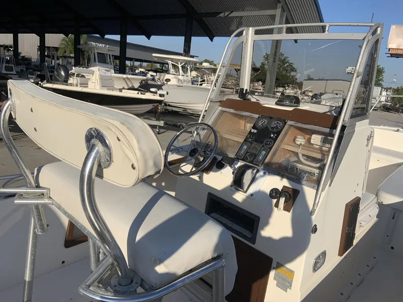 Slide: The Image of 1988 Mako 231 Center Console boat interior with steering wheel and control panel. - 5