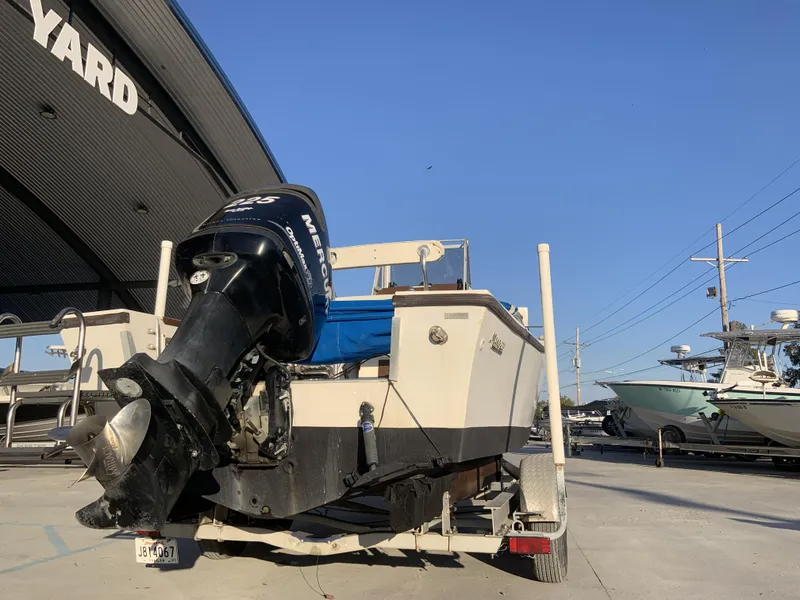 Slide: The Image of 1988 Mako 231 Center Console boat on trailer with Mercury outboard motor at a boatyard. - 7