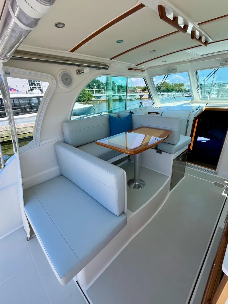 Slide: The Image of 2023 Back Cove 34O yacht interior with elegant seating and wooden table. - 13