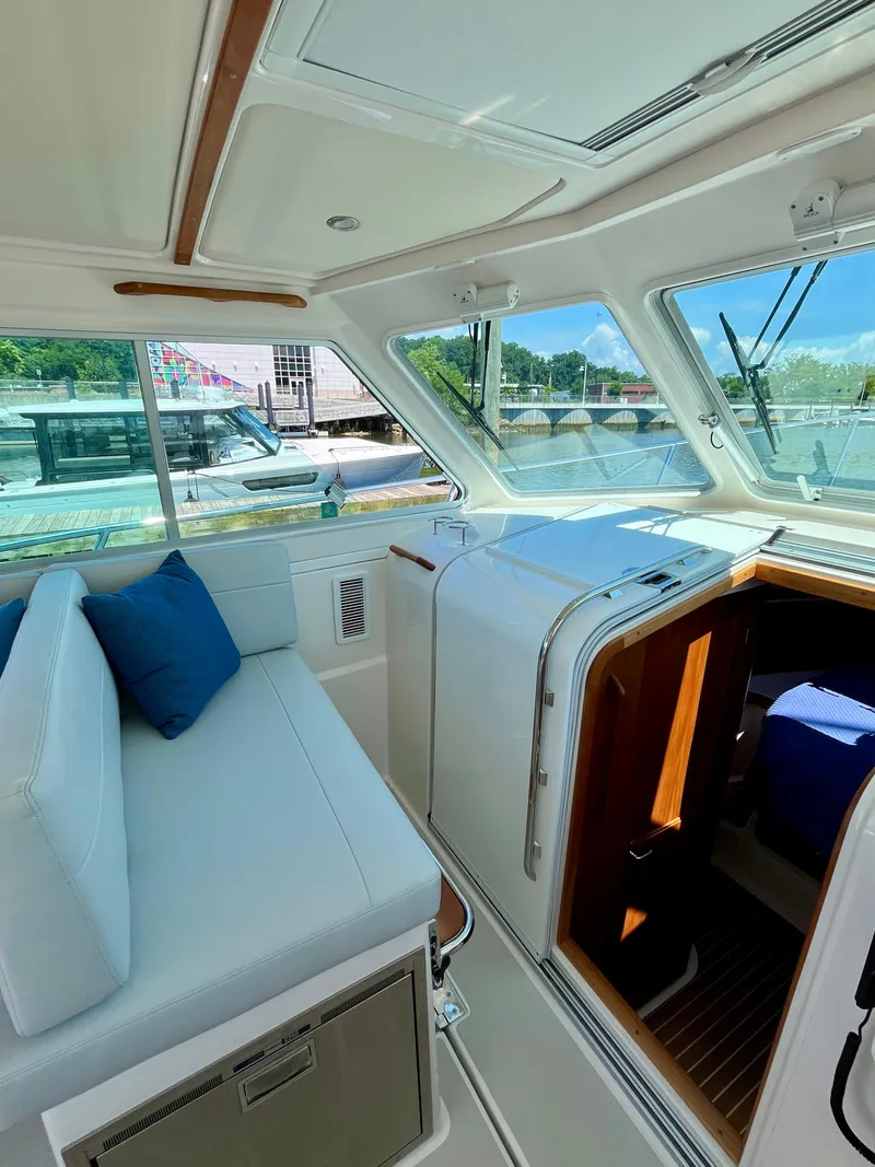 Slide: The Image of Interior of 2023 Back Cove 34O yacht with white seating and blue cushions. - 17