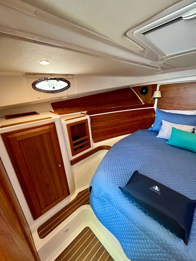 Slide: The Image of Luxurious cabin interior of 2023 Back Cove 34O with wood accents and cozy bedding. - 22