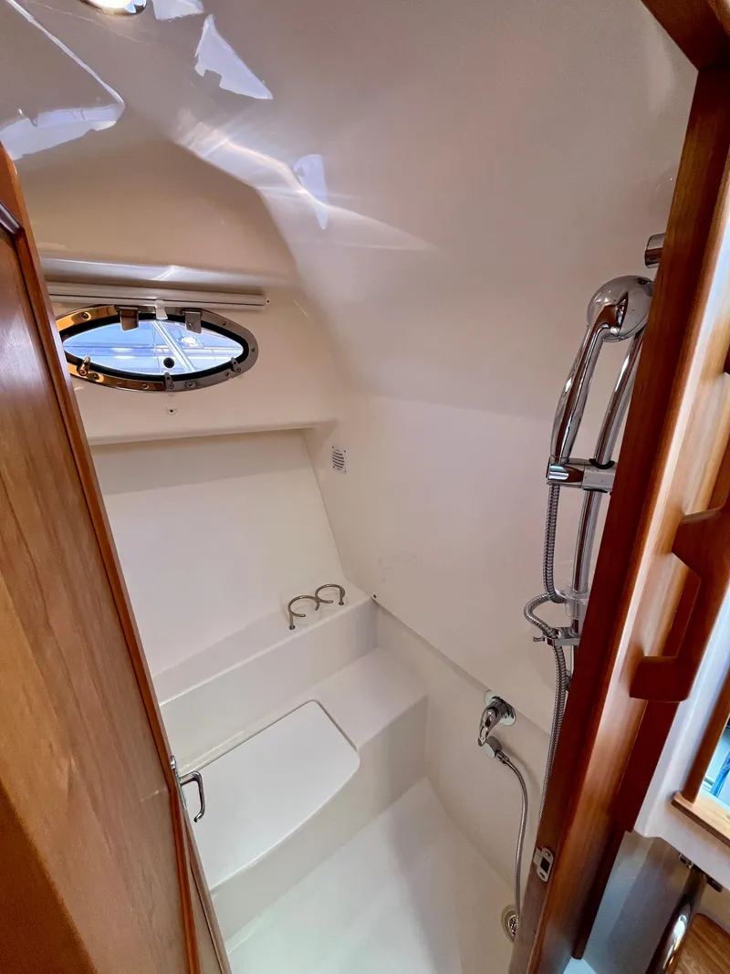 Slide: The Image of 2023 Back Cove 34O yacht bathroom with shower and porthole window. - 26