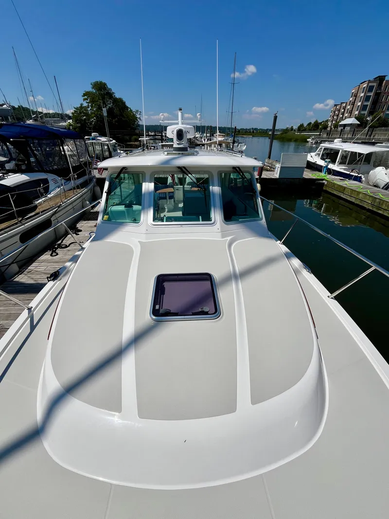 Slide: The Image of 2023 Back Cove 34O boat docked at marina under clear blue sky. - 42