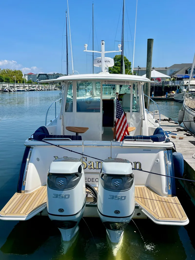 Slide: The Image of 2023 Back Cove 34O boat docked with dual Suzuki 350 engines and American flag. - 6