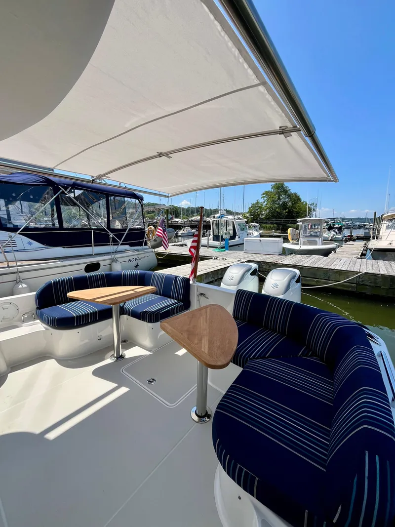 Slide: The Image of 2023 Back Cove 34O yacht with shaded seating area at marina. - 9