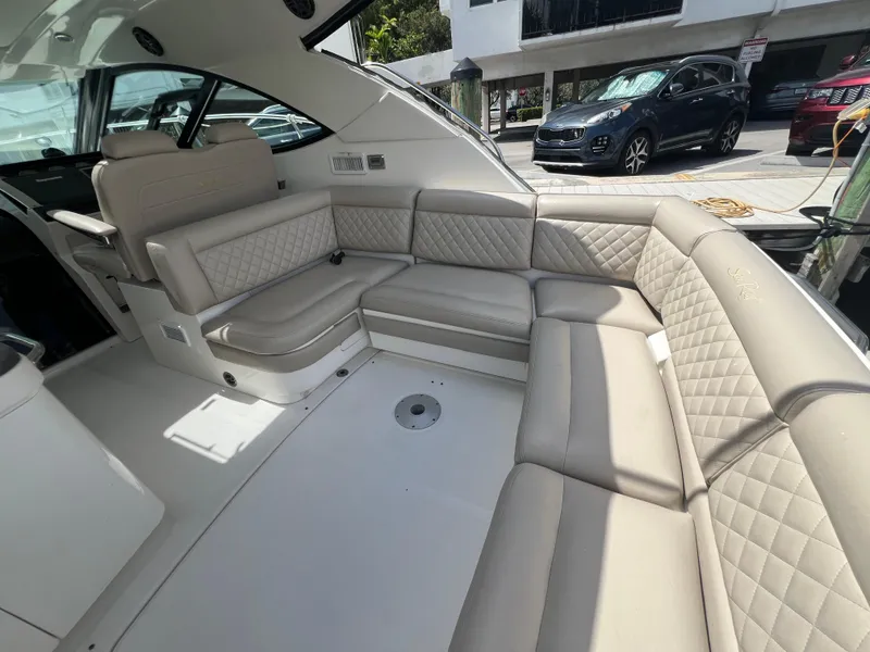 Slide: The Image of Luxurious interior seating of 2013 Sea Ray 410 Sundancer yacht, featuring beige upholstery. - 13