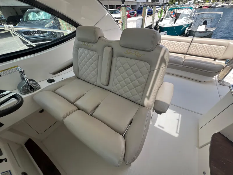 Slide: The Image of Luxurious seating on a 2013 Sea Ray 410 Sundancer yacht, docked near other boats. - 14