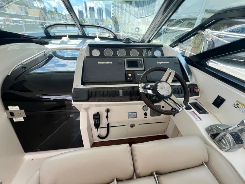 Slide: The Image of 2013 Sea Ray 410 Sundancer helm with Raymarine electronics and modern steering wheel. - 16