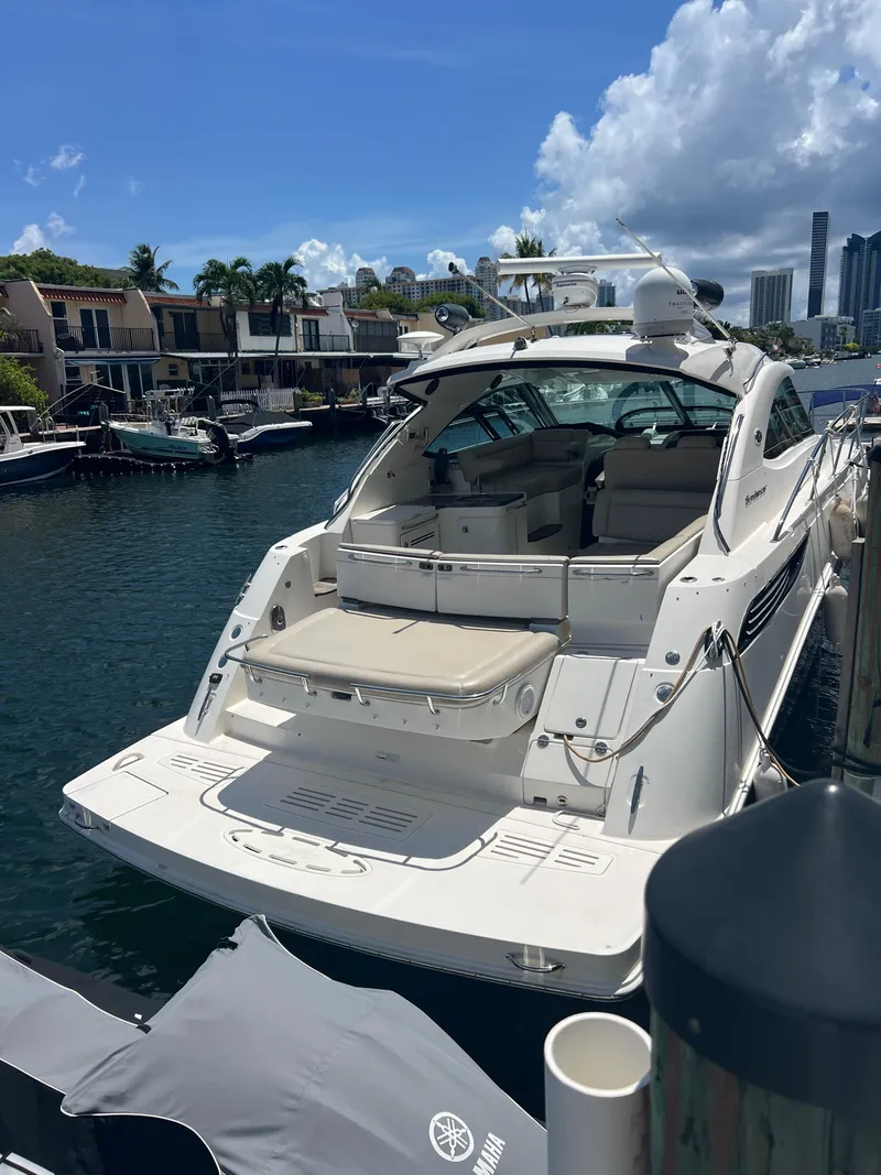 Slide: The Image of 2013 Sea Ray 410 Sundancer yacht docked in a sunny marina. - 18