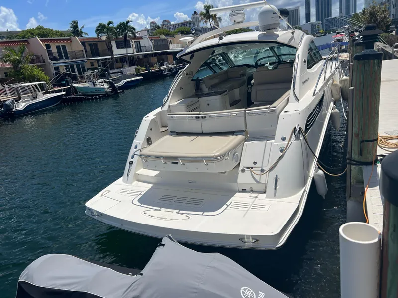 Slide: The Image of 2013 Sea Ray 410 Sundancer yacht docked at marina, sunny day, waterfront homes in background. - 19