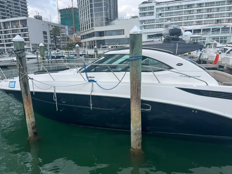 Slide: The Image of 2013 Sea Ray 410 Sundancer yacht docked at a marina with modern buildings. - 20