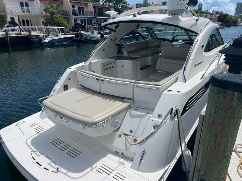 Slide: The Image of 2013 Sea Ray 410 Sundancer yacht docked, featuring spacious seating and sleek design. - 3