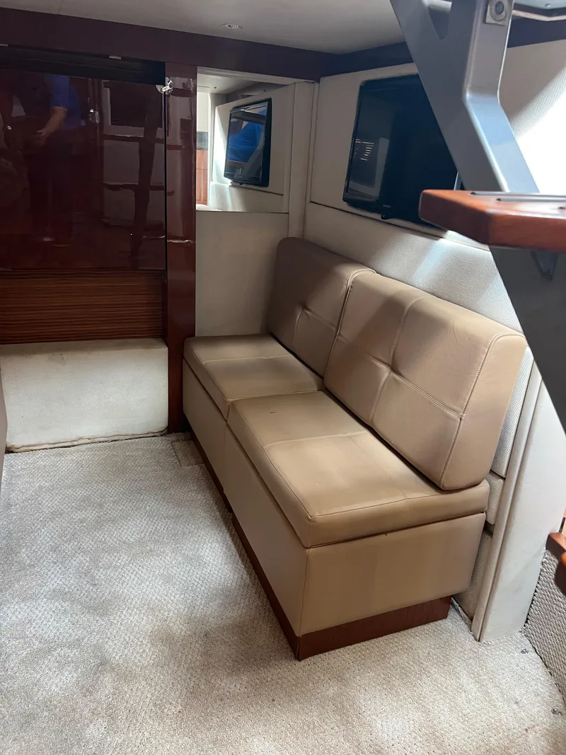 Slide: The Image of Interior of 2013 Sea Ray 410 Sundancer with beige seating and carpeted floor. - 31
