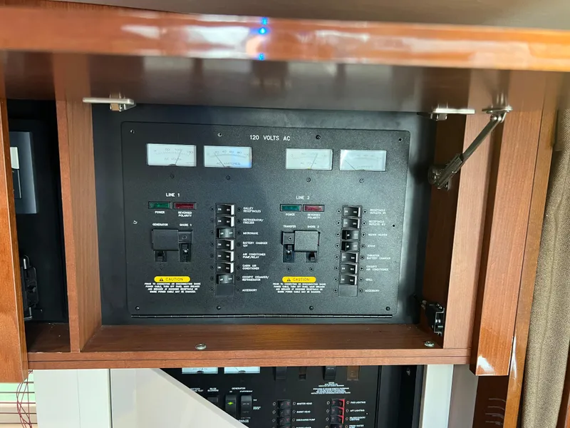 Slide: The Image of Electrical panel inside 2013 Sea Ray 410 Sundancer yacht, featuring various switches and gauges. - 34