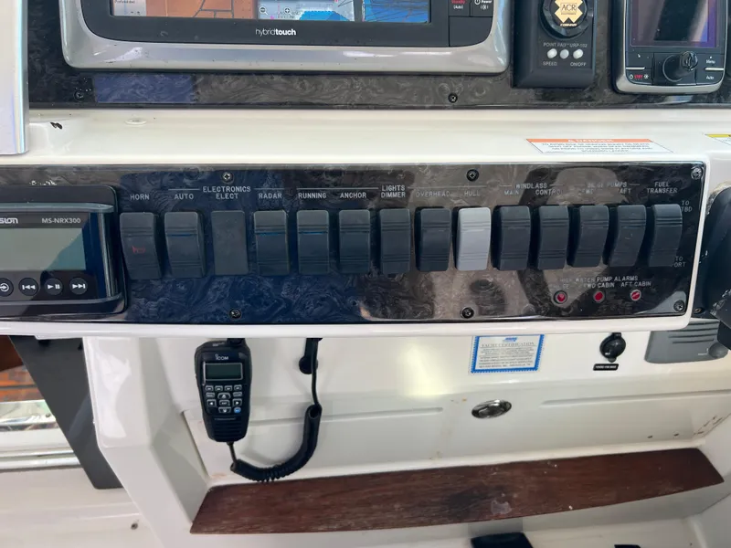 Slide: The Image of Control panel of a 2013 Sea Ray 410 Sundancer boat with various switches and displays. - 35