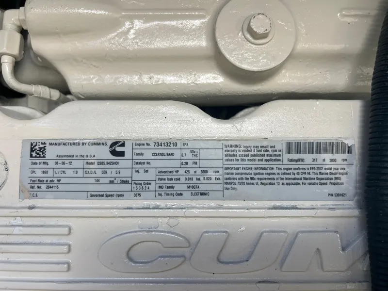 Slide: The Image of Cummins engine label on a 2013 Sea Ray 410 Sundancer, detailing specifications and warnings. - 44