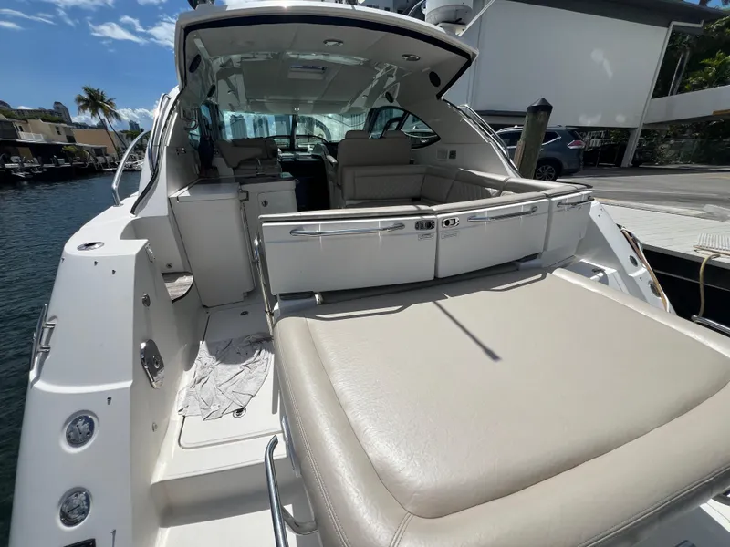 Slide: The Image of 2013 Sea Ray 410 Sundancer yacht with spacious seating and sleek design at a marina. - 7