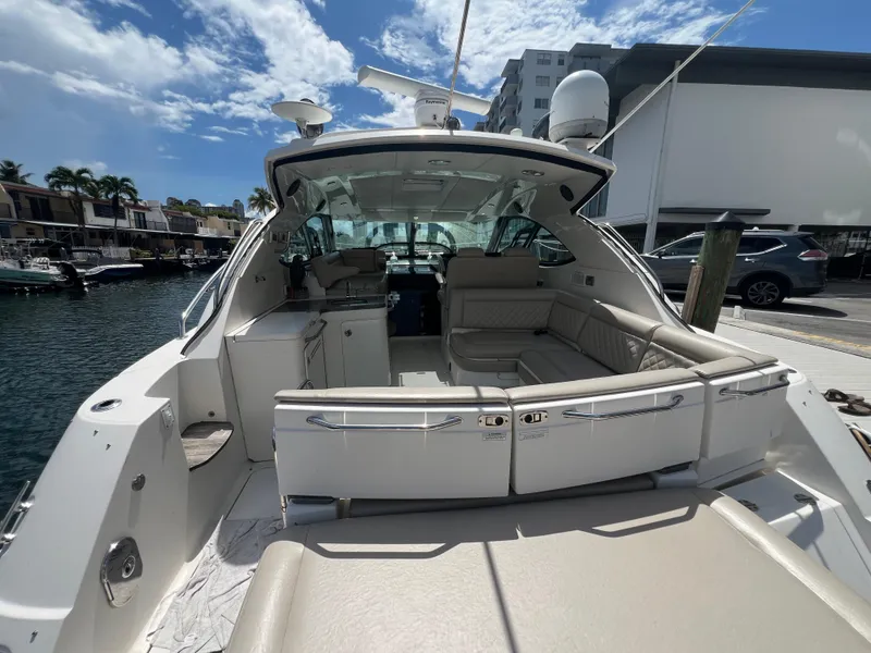 Slide: The Image of 2013 Sea Ray 410 Sundancer yacht with spacious seating, docked under a clear blue sky. - 8
