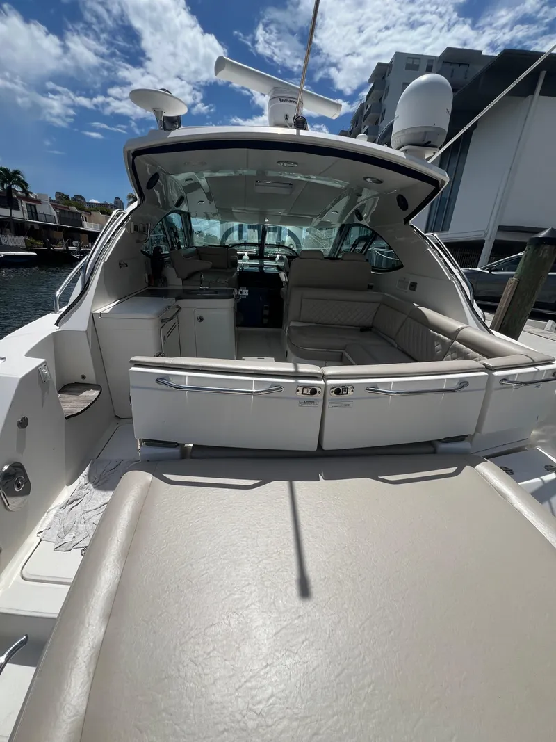 Slide: The Image of 2013 Sea Ray 410 Sundancer yacht with spacious seating and modern amenities under a clear sky. - 9