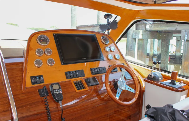 Slide: The Image of 2008 Hinckley Talaria 38R Convertible helm with wooden dashboard and modern navigation controls. - 14