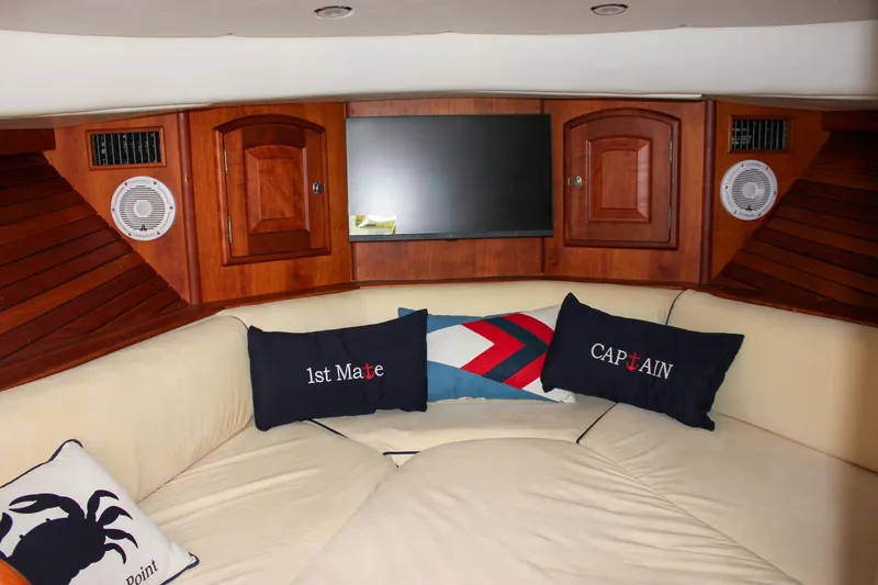 Slide: The Image of Interior of 2008 Hinckley Talaria 38R Convertible with cozy seating and nautical-themed pillows. - 38
