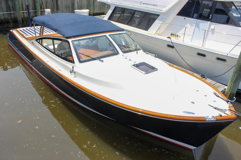 Slide: The Image of 2008 Hinckley Talaria 38R Convertible docked, featuring sleek design and blue canopy. - 4