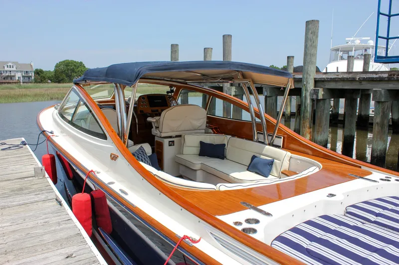 Slide: The Image of 2008 Hinckley Talaria 38R Convertible yacht docked, featuring elegant seating and polished wood finish. - 46