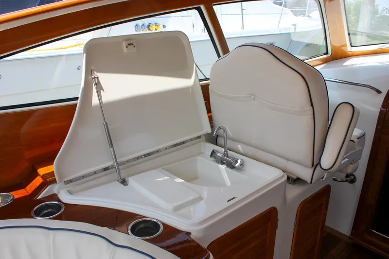 Slide: The Image of 2008 Hinckley Talaria 38R Convertible interior with white seating and built-in sink. - 7