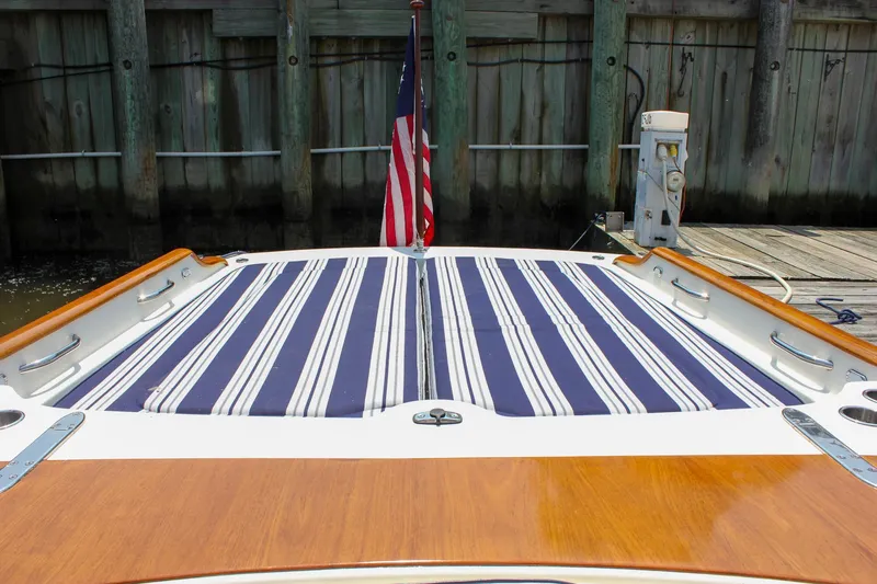 Slide: The Image of 2008 Hinckley Talaria 38R Convertible boat with striped deck cushions and American flag. - 10