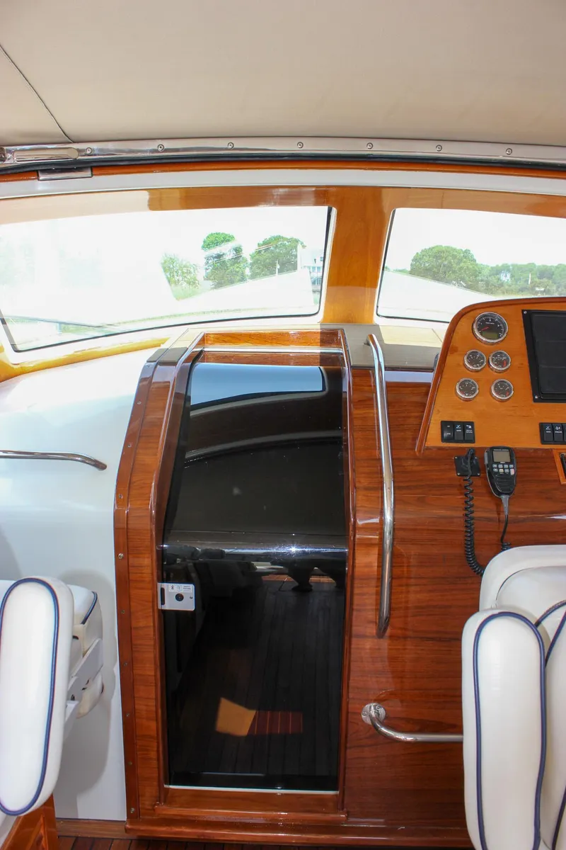 Slide: The Image of Interior of 2008 Hinckley Talaria 38R Convertible yacht with polished wood and navigation controls. - 12