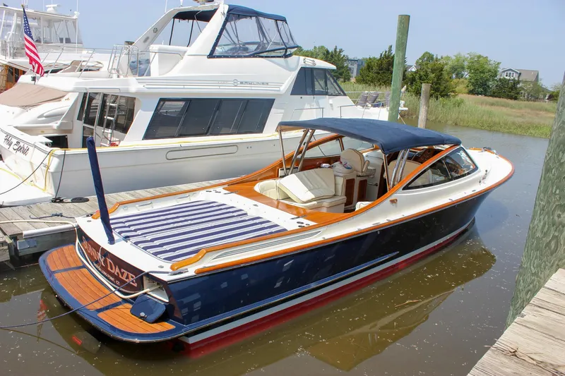 Slide: The Image of 2008 Hinckley Talaria 38R Convertible docked in a marina, featuring elegant design and blue canopy. - 3
