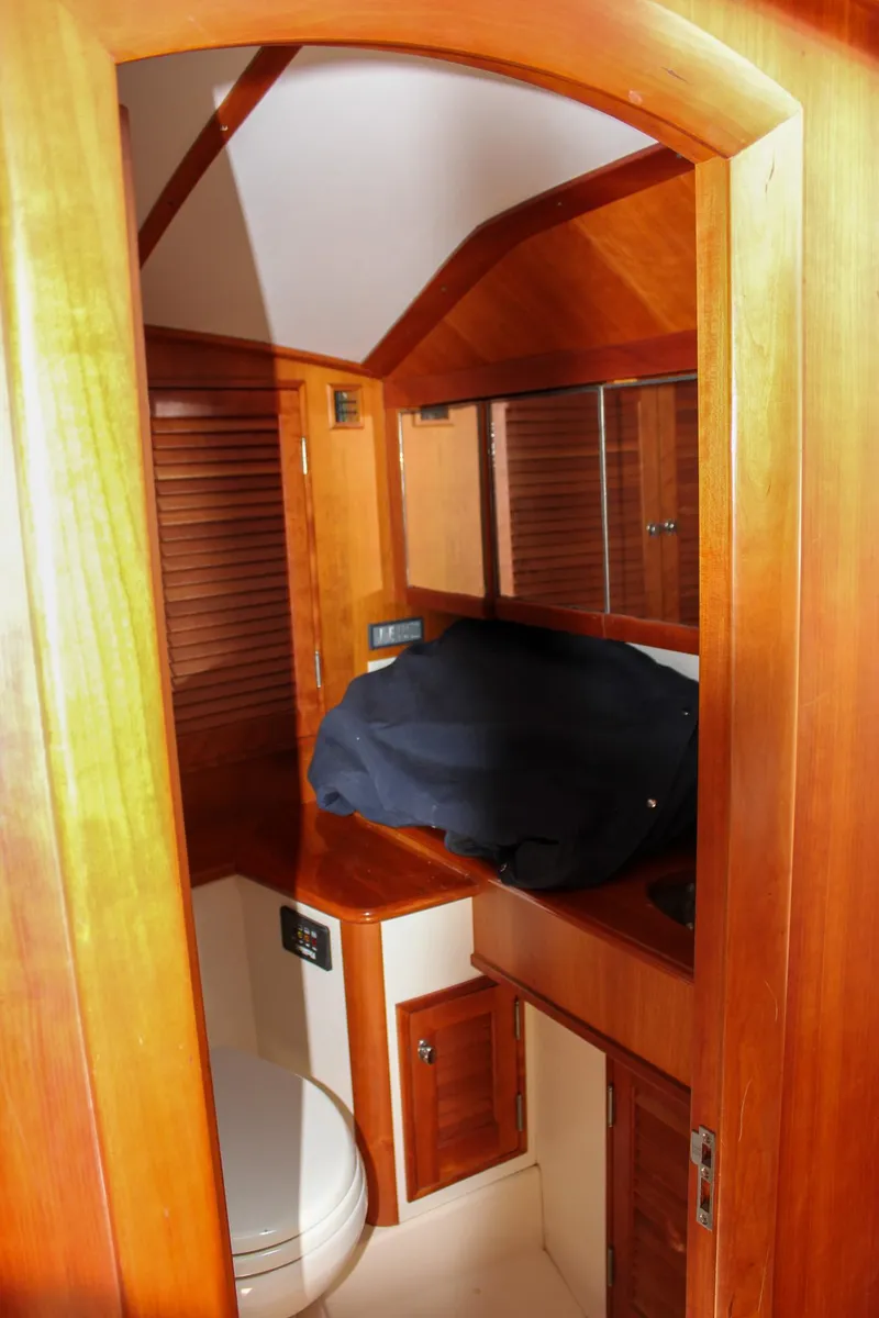 Slide: The Image of Interior of 2008 Hinckley Talaria 38R Convertible, featuring wooden cabinetry and compact bathroom. - 33