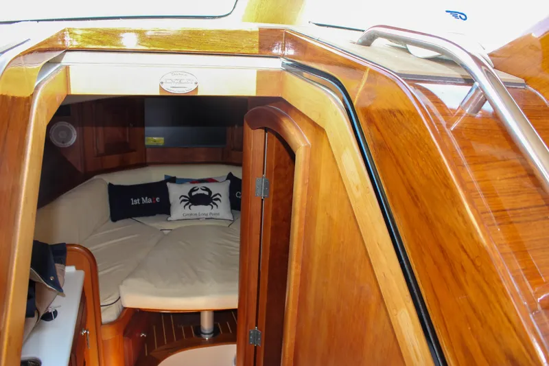 Slide: The Image of Interior of 2008 Hinckley Talaria 38R Convertible, featuring cozy cabin with cushions and wood finish. - 41