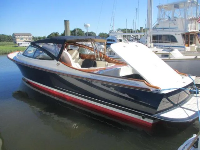 Slide: The Image of 2008 Hinckley Talaria 38R Convertible boat docked in marina, featuring sleek design and open deck. - 63