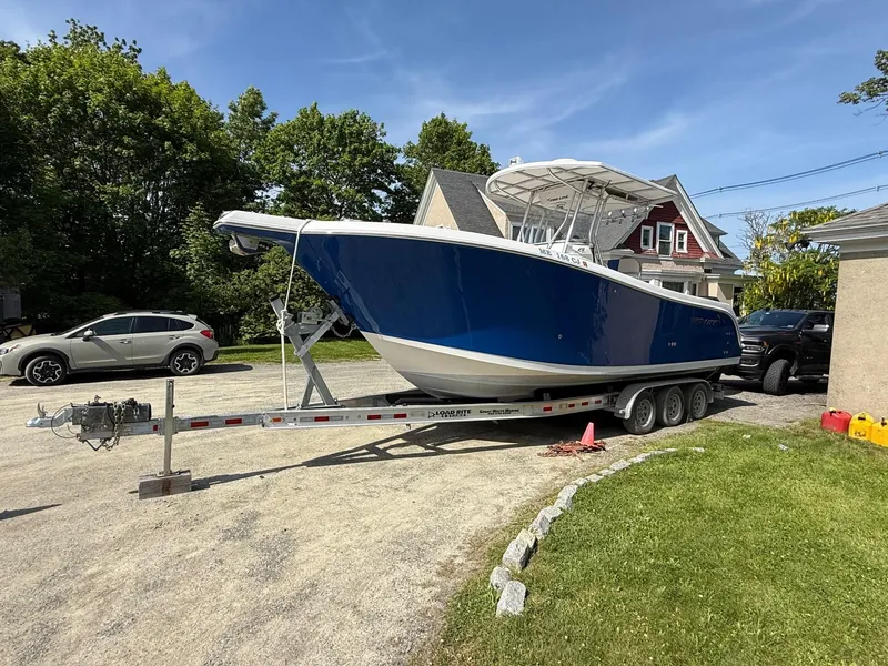 Slide: The Image of 2008 Pro-Line 29 Grand Sport boat on trailer, parked in a residential driveway. - 1