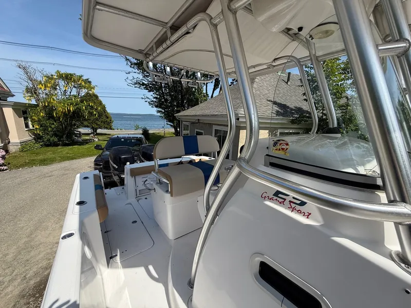 Slide: The Image of 2008 Pro-Line 29 Grand Sport boat with seating, parked near a coastal home. - 15
