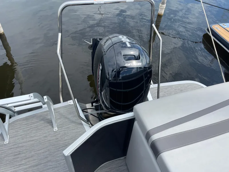 Slide: The Image of 2022 Bennington 21 SX boat with Mercury outboard motor on a calm lake. - 22